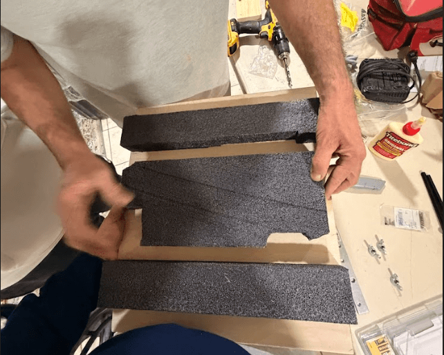 Wheelchair frame being assembled with tools and clamps visible in the workshop