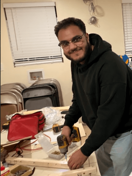 Michael and Peter cutting wood in the workshop during the build process