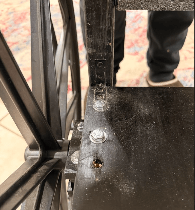 Foot rest after reinforcement showing multiple 90-degree brackets for improved load distribution